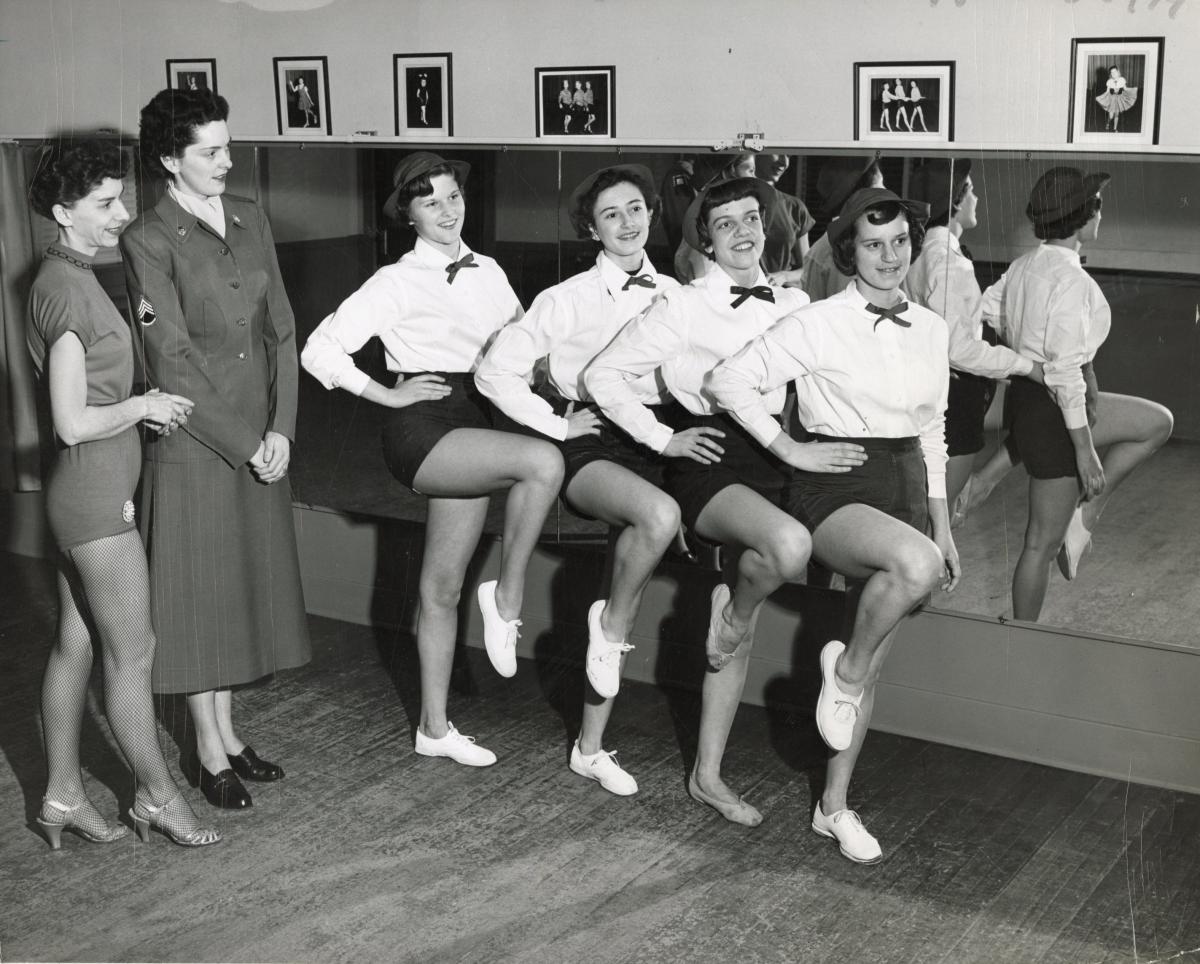 Pollyettes drill team and instructors posing in a studio.