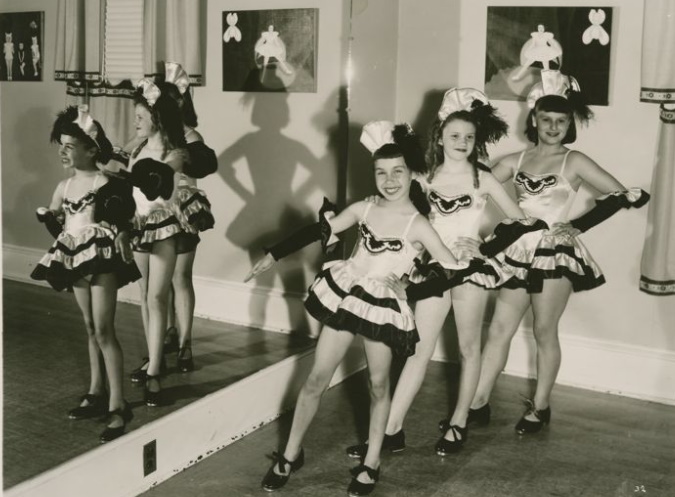 Child tap dancers posing in recital costumes